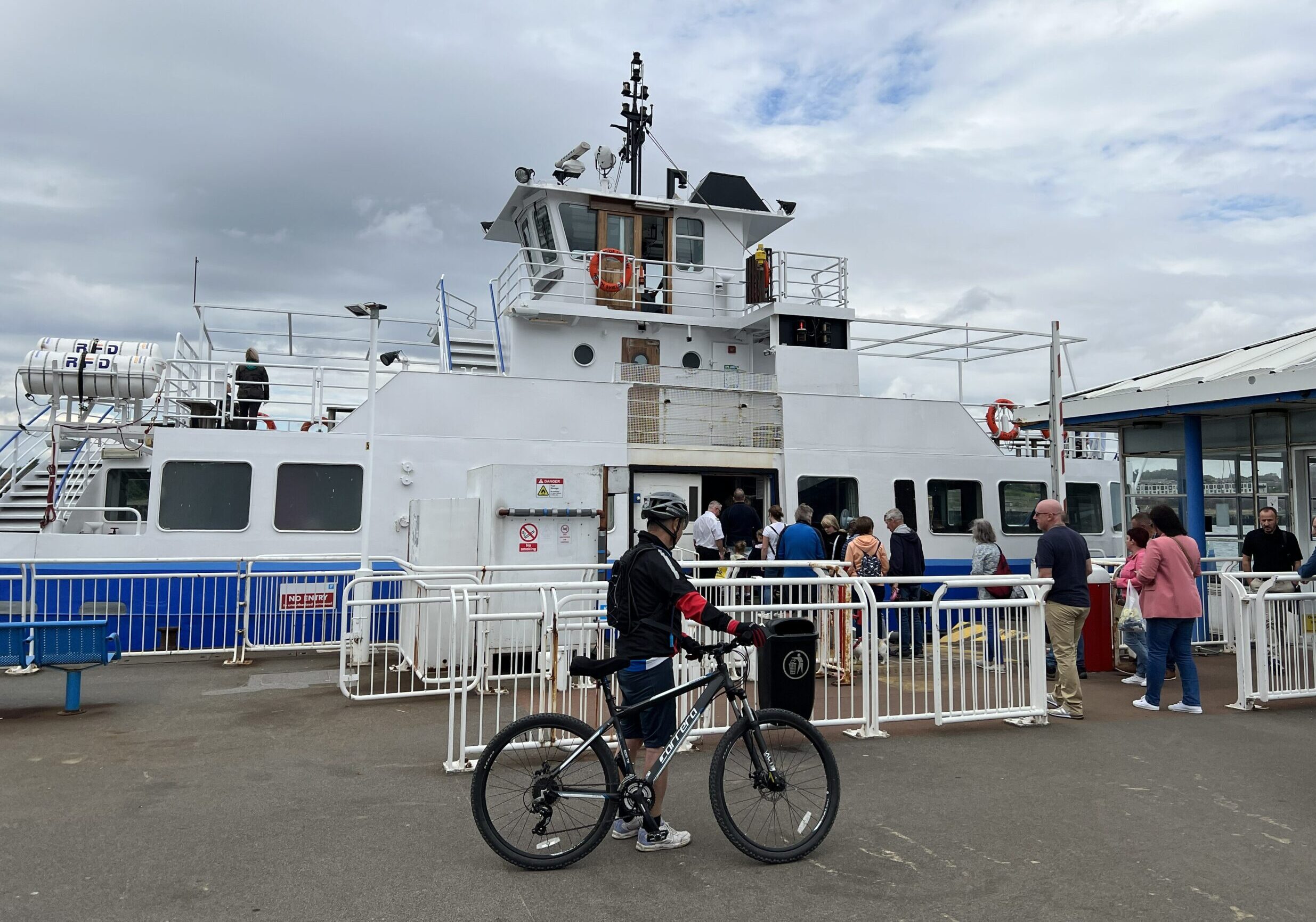A cyclist and other customers wait to board the Shields Ferry